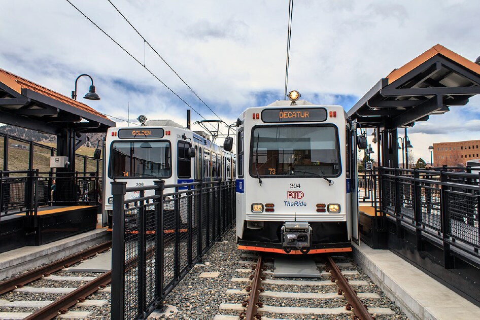 Two RTD light rail cars, signed Golden and Decatur, at a West Rail station